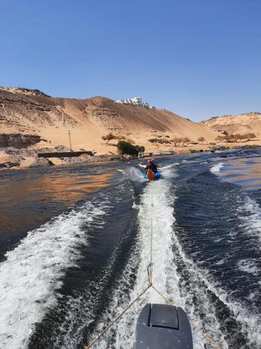 a person is being pulled by a boat in the water at Adad Noubian House in Aswan