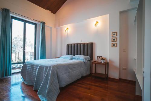 a bedroom with a bed and a large window at Beautiful house in the Sacred Valley "Casa Julia Cusco" in Cusco