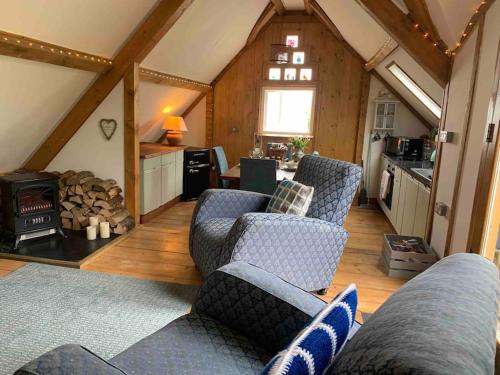 a living room with two couches and a kitchen at AppleTree Barn - Pembrokeshire Coast National Park in Pembroke