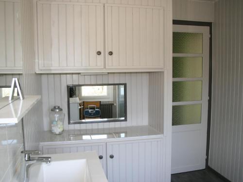 une salle de bain blanche avec un lavabo et un miroir dans l'établissement Maison confortable avec jardin, proche centre-ville et circuit 24h du Mans - FR-1-410-271, au Mans