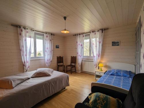a bedroom with two beds and a table and chairs at Gîte spacieux en ancienne ferme rénovée, idéal pour familles et amis – proche randos et sites touristiques - FR-1-589-6 in Ban-sur-Meurthe-Clefcy
