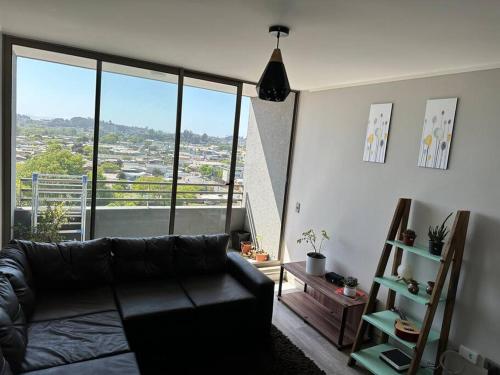sala de estar con sofá y ventana grande en Apartamento en Concepción, en Concepción