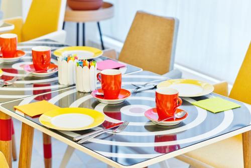a dining table with red cups and plates on it at Hotel Joke - Astotel in Paris