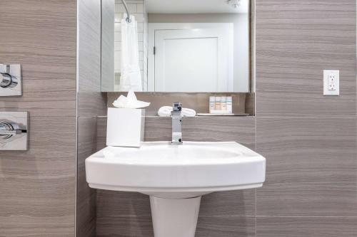 a bathroom with a white sink and a mirror at Infinity Hotel San Francisco, Tapestry Collection by Hilton in San Francisco