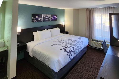 A bed or beds in a room at Sleep Inn Olathe - Kansas City