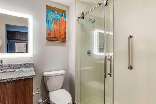 a bathroom with a toilet and a glass shower at MainStay Suites Ocean City West in Ocean City