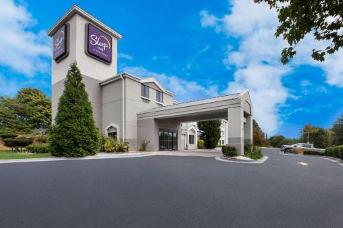 a large white building with a spa sign on it at Sleep Inn in Lithonia