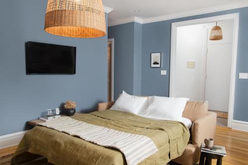 1 dormitorio azul con 1 cama y TV en Sleepover No 103 en Filadelfia
