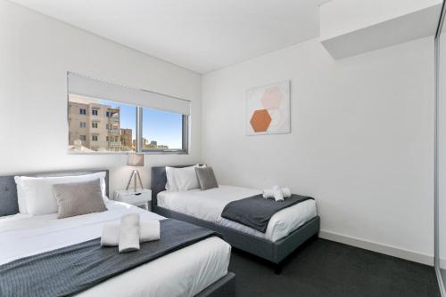 a bedroom with two beds and a window at U4/51 Luxe Chic in Perth