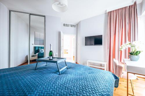 Un dormitorio con una cama azul con una mesa. en Wola Tower 3 rooms, 16th floor with a view, 80m2, free garage, en Varsovia