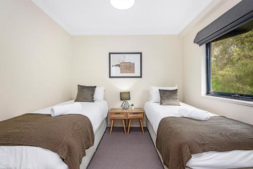 two twin beds in a room with a window at 412: Marvelous Mounts Bay in Perth