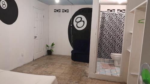 una stanza con servizi igienici e una porta con il numero otto di Miss Magi cahuita rooms a Cahuita