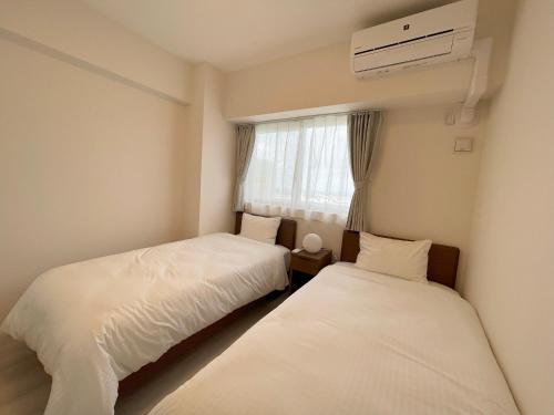 Katil atau katil-katil dalam bilik di ＆Monde. Okinawa Arena Condominium