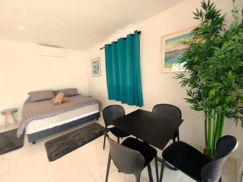 um quarto com uma cama, uma mesa e cadeiras em MOOREA - O Motu em Temae