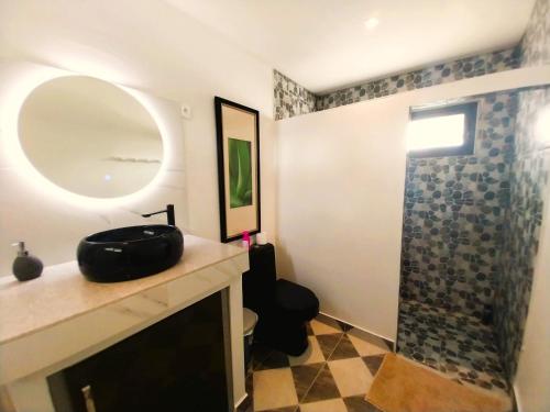 W łazience znajduje się umywalka, lustro i prysznic. w obiekcie MOOREA - O Motu w mieście Temae