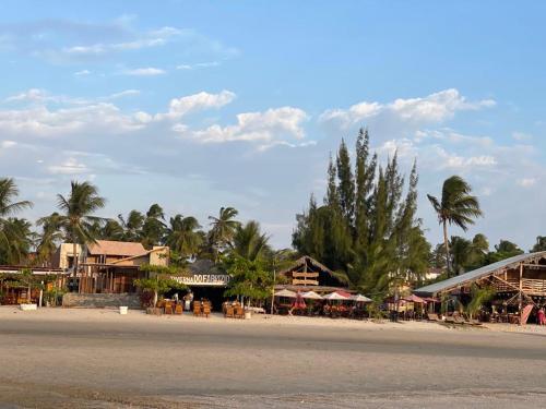 una playa con casas, palmeras y una calle en AP CAMOCIM praia bangalôkite13, en Maceió