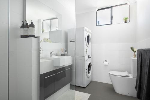 un baño blanco con lavadora y secadora. en U6/560 Modern Trendy en Perth