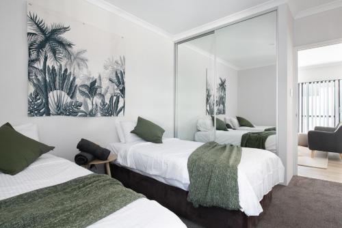 1 dormitorio con 2 camas y espejo en U6/560 Modern Trendy en Perth