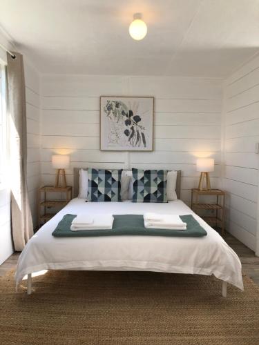 a bedroom with a large white bed with two lamps at Sassafras Springs in Ellendale