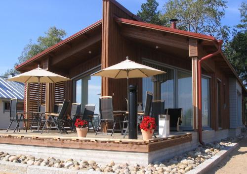 a house with chairs and umbrellas on a patio at Villa Elba in Kokkola