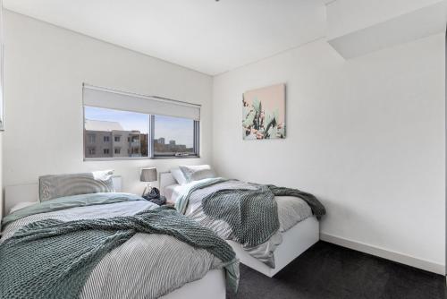 Cette chambre blanche dispose de 2 lits et d'une fenêtre. dans l'établissement U8/51 Bright 3 bd city, à Perth