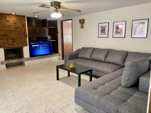 a living room with a couch and a tv at Casa Tehuantepec, 5hab 4.5baños in Hermosillo