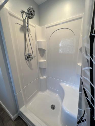 a white bathroom with a shower and a toilet at Buckhorn Cabin in Mathias