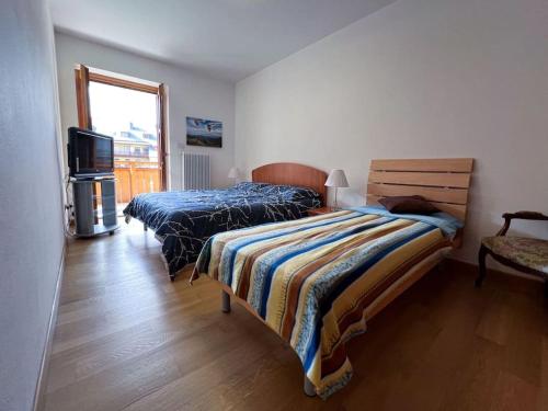 a bedroom with two beds and a television at Civico 11 in Tarvisio