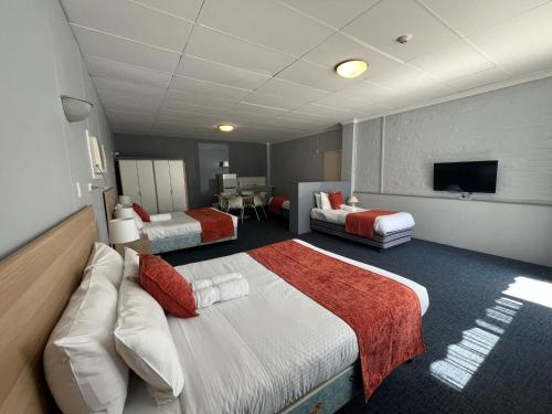 um quarto de hotel com duas camas e uma televisão de ecrã plano em Princes Lodge Motel em Adelaide