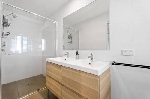 ein weißes Badezimmer mit Waschbecken und Dusche in der Unterkunft Stunning Entertainer with private beach in Gold Coast