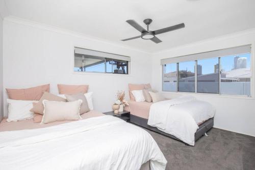 zwei Betten in einem Schlafzimmer mit Deckenventilator in der Unterkunft Stunning Entertainer with private beach in Gold Coast