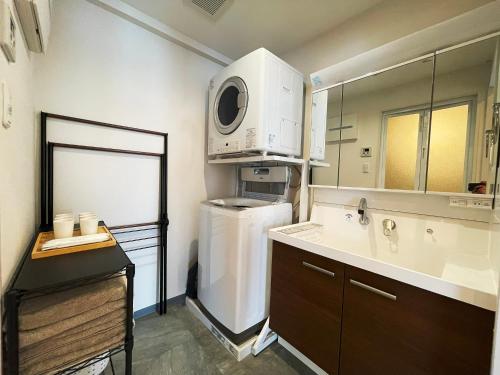 eine kleine Küche mit einem Kühlschrank und einer Mikrowelle in der Unterkunft ＆Monde. Okinawa Arena Condominium in Okinawa