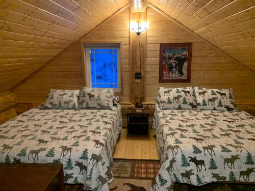 um quarto com 2 camas num chalé de madeira em The Chena Valley Cabin, perfect for aurora viewing em Pleasant Valley