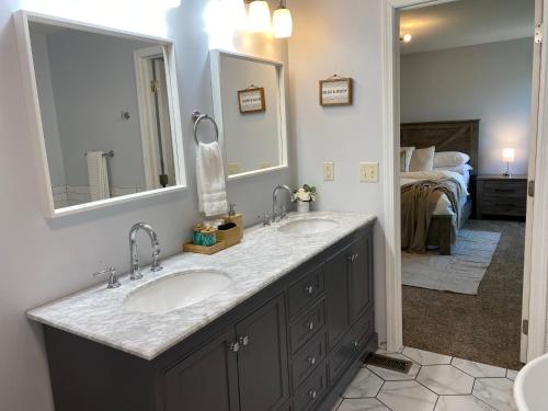La salle de bains est pourvue de 2 lavabos et d'un grand miroir. dans l'établissement Newley Remodel 5 - Bedroom Home Sleeps 16, à Groveport