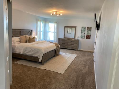 een slaapkamer met een bed, een dressoir en een raam bij Newley Remodel 5 - Bedroom Home Sleeps 16 in Groveport