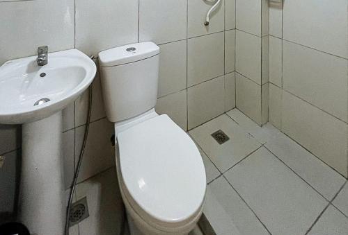 a white bathroom with a toilet and a sink at RedDoorz @ CMS Apartelle Olongapo City in Olongapo