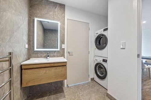 a bathroom with a sink and a washing machine at Central Park Residence in Auckland