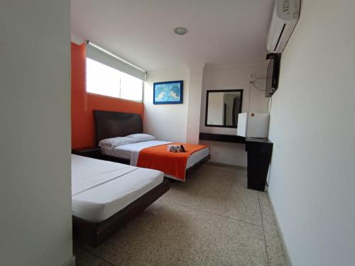 a hotel room with two beds and a television at HOTEL AVANTY INN in Barranquilla