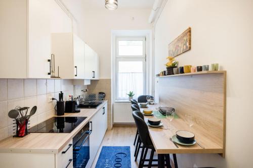 una cocina con mesa de madera y sillas. en Izabella Apartment, en Budapest