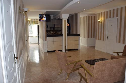 een woonkamer met een tafel en stoelen en een keuken bij Crossway Tbilisi Hotel in Tbilisi City