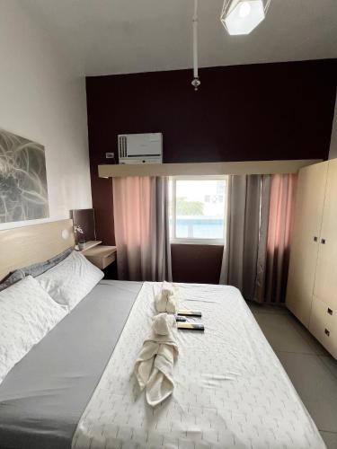 un osito de peluche sentado en una cama en un dormitorio en San Marino Residences en Cebú