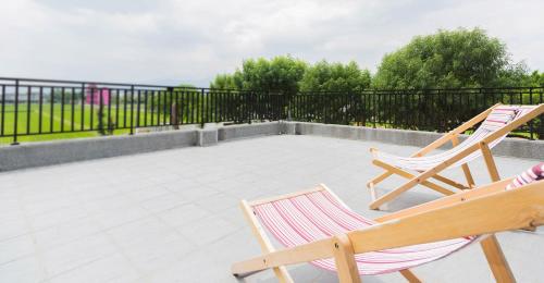 two chairs sitting on a patio with a fence at Muzhe-Fascinating in Dongshan