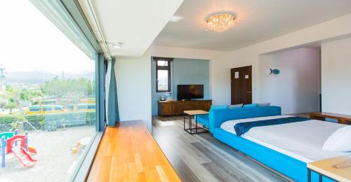 a bedroom with a blue bed and a large window at Muzhe-Fascinating in Dongshan