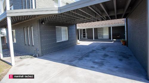 a building with an empty driveway in front of it at Blue Pool Hideaway Bermagui in Bermagui