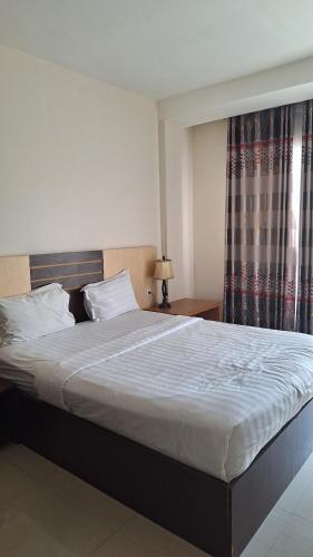 a large bed in a bedroom with a window at D'Sapphire Hasanah Guesthouse in Blimbing