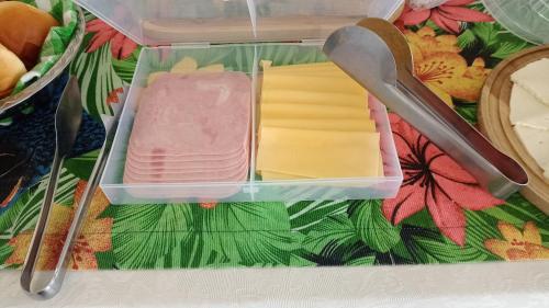 un recipiente de plástico lleno de diferentes tipos de queso en Mansão de Pirah Suites en Niterói