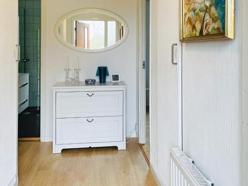uma cómoda branca num quarto com um espelho em Holiday home KYRKESUND VI em Kyrkesund