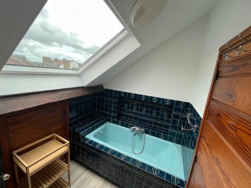 a bathroom with a bath tub with a window at Grand studio 65m² à Saint-Esprit, Bayonne - WiFi, près gare - FR-1-239-996 in Bayonne