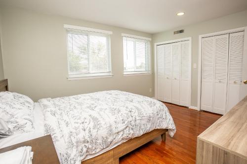 a bedroom with a bed and two windows at Comfy and Cozy-Min to National Mall Great Location in Arlington