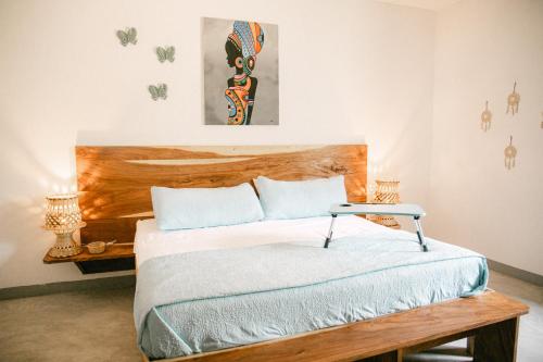 a bedroom with a bed with a wooden headboard at Villa Makai 1 Orange in El Paredón Buena Vista